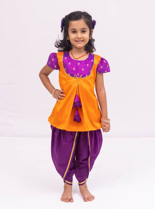 Purple mysore silk tulip dhoti and orange raw silk tunics set with an intricate embroidered yoke pattern for Girls.Let your princess be as comfortable as in her casuals with carefully designed & crafted Comfort Ethnic Wear by Soyara Ethnics.Keep her fashion quotient high with timeless patterns, vibrant combinations and royal textiles.