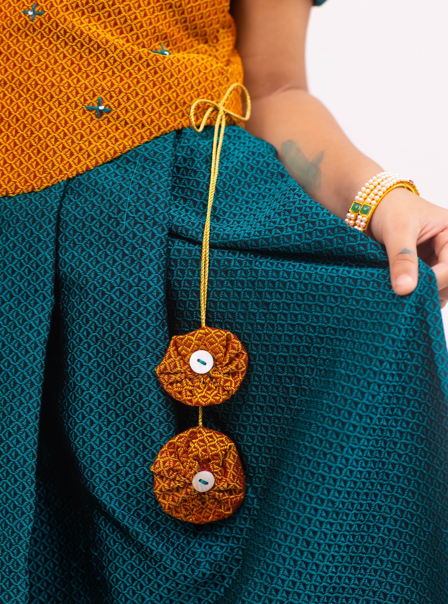 Peacock Green Khunn Dress with Contrast Turmeric Yellow hand embroidered blouse with cute puff sleeves. Apple cut blouse has cute flower latkans on both sides that dangle while walking. Also Unique Patti border of khunn is something not to miss for Khunn lovers