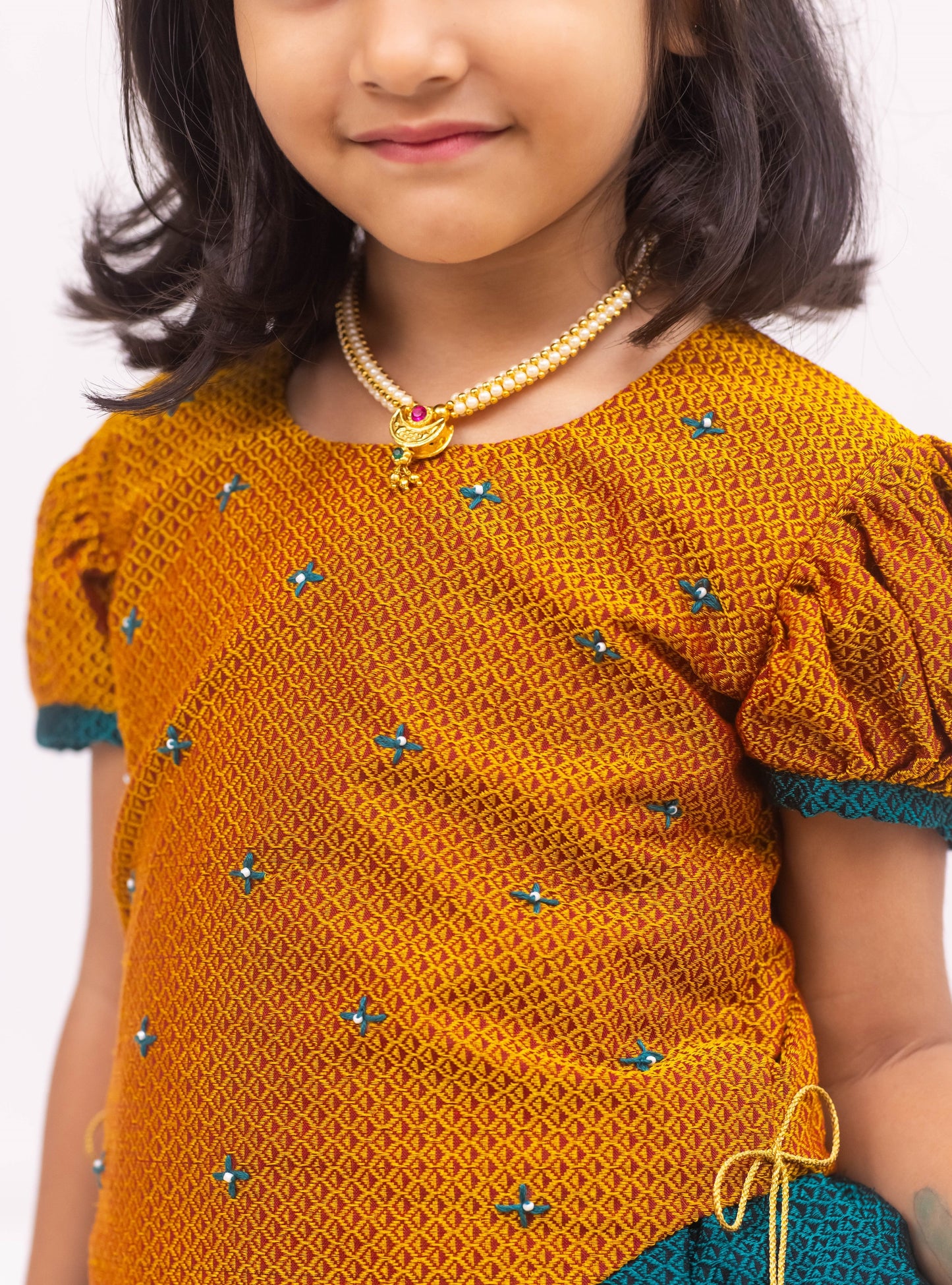 Peacock Green Khunn Dress with Contrast Turmeric Yellow hand embroidered blouse with cute puff sleeves. Apple cut blouse has cute flower latkans on both sides that dangle while walking. Also Unique Patti border of khunn is something not to miss for Khunn lovers