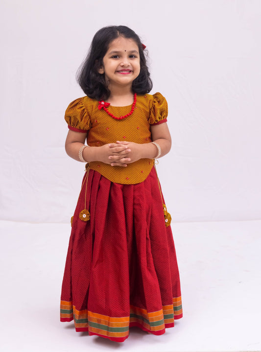 Bright Red Khunn Dress with Contrast Turmeric Yellow hand embroidered blouse with cute puff sleeves. Apple cut blouse has cute flower latkans on both sides that dangle while walking. Also Unique Patti border of khunn is something not to miss for Khunn lovers