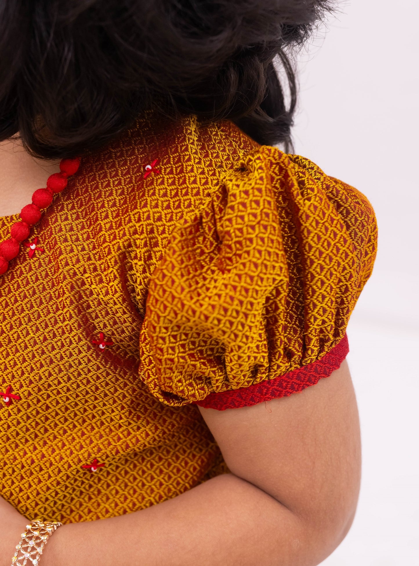 Bright Red Khunn Dress with Contrast Turmeric Yellow hand embroidered blouse with cute puff sleeves. Apple cut blouse has cute flower latkans on both sides that dangle while walking. Also Unique Patti border of khunn is something not to miss for Khunn lovers