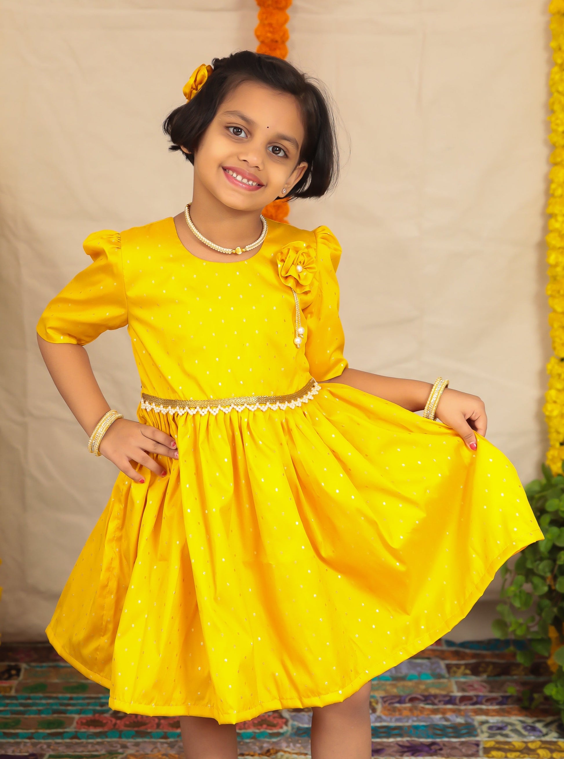 Yellow taffeta dress with elbow length puff sleeves for Girl.Let your princess be as comfortable as in her casuals with carefully designed & crafted Comfort Ethnic Wear by Soyara Ethnics.Keep her fashion quotient high with timeless patterns, vibrant combinations and royal textiles.