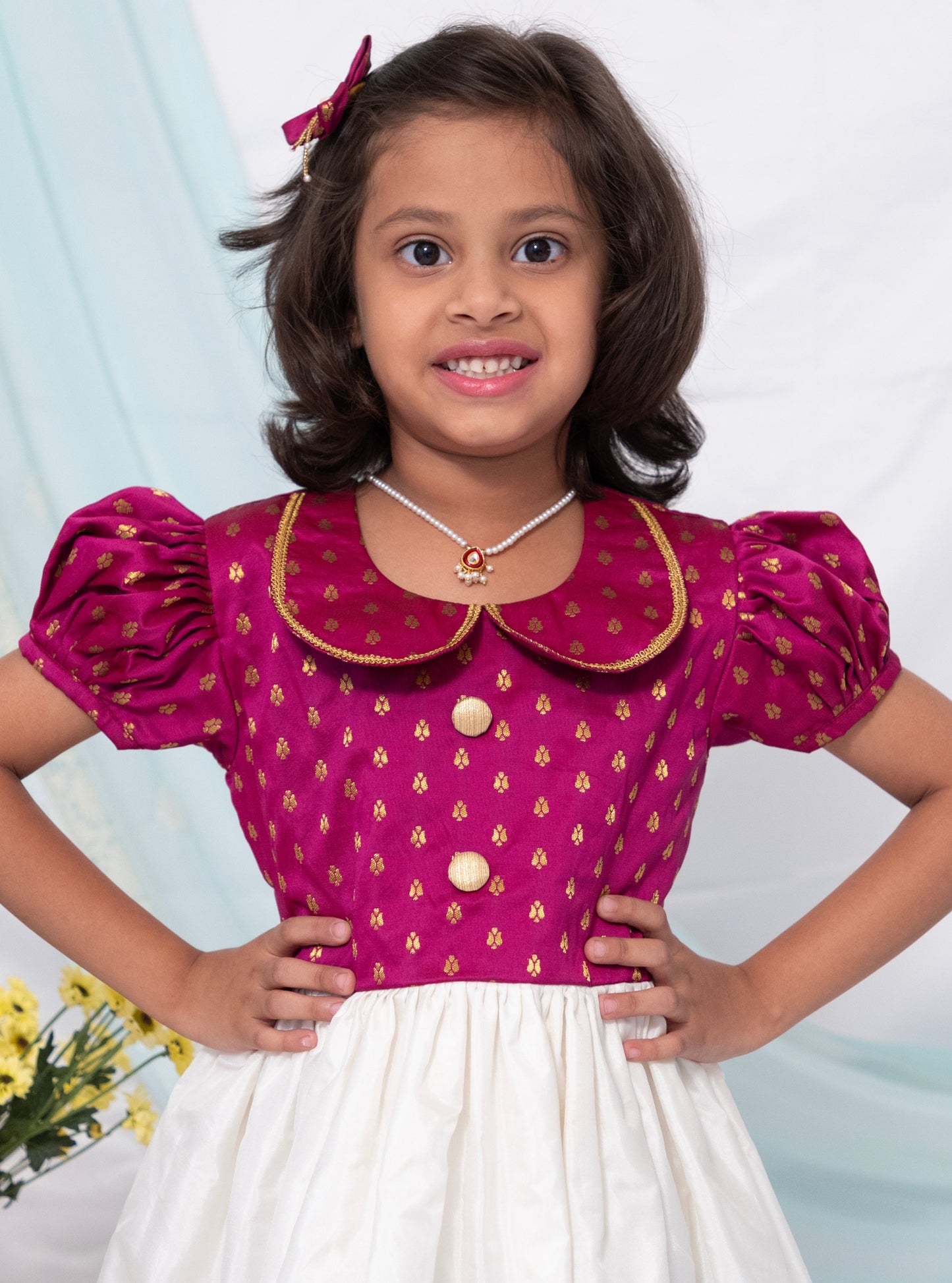 Magenta brocade silk and Ivory Mysore silk dress with Peter pan collar and puffed sleeves for Girl.Let your princess be as comfortable as in her casuals with carefully designed & crafted Comfort Ethnic Wear by Soyara Ethnics.Keep her fashion quotient high with timeless patterns, vibrant combinations and royal textiles.