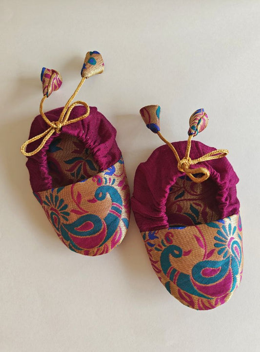 Magenta Peacock Paithani Motif, adjustable unisex Newborn Baby Mojaris /Booties.Paithani motif unisex booties for baby. Team these with any ethnic dress and complete the royal look! Completely made out of fabrics inside out , make these booties perfectly comfy first ethnic wear for the newborn.