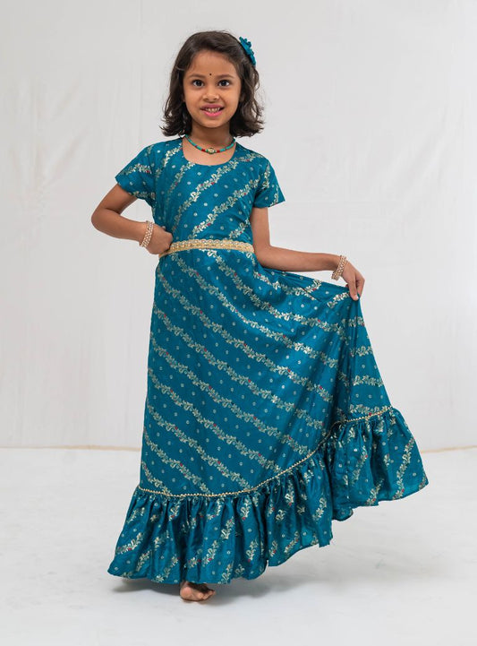 Peacock green banaras satin brocade silk gown with cap sleeves and ruffled flare for Girls.Let your princess be as comfortable as in her casuals with carefully designed & crafted Comfort Ethnic Wear by Soyara Ethnics.Keep her fashion quotient high with timeless patterns, vibrant combinations and royal textiles.