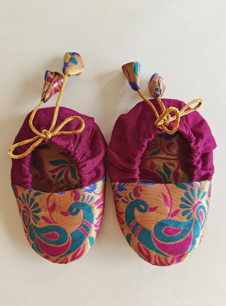 Magenta Peacock Paithani Motif, adjustable unisex Newborn Baby Mojaris /Booties.Paithani motif unisex booties for baby. Team these with any ethnic dress and complete the royal look! Completely made out of fabrics inside out , make these booties perfectly comfy first ethnic wear for the newborn.