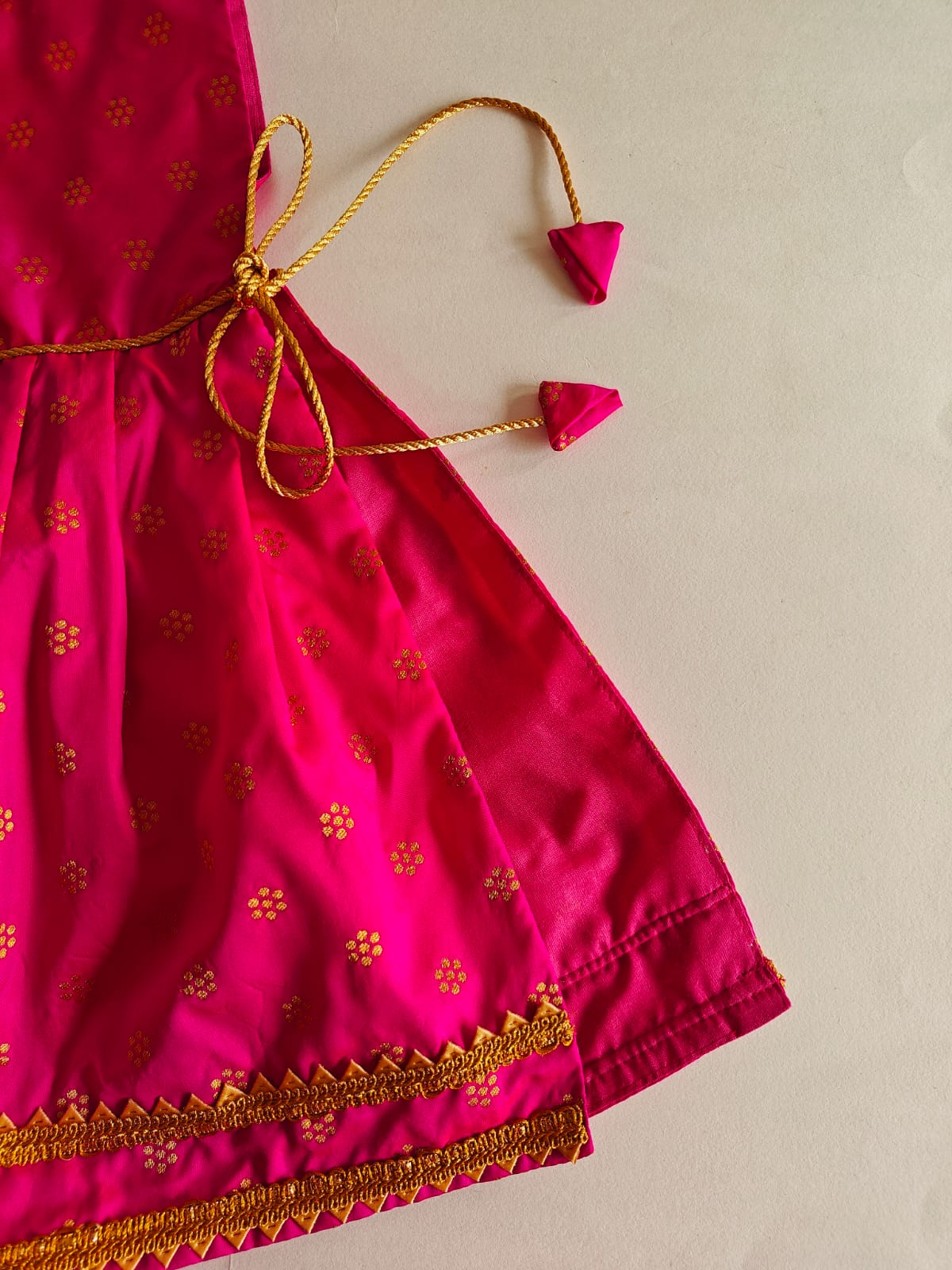 Dark Pink brocade silk kunchi with beautiful golden lace. Traditional design with a twist of small details like golden tassel and cute latkans. A must have for a naming ceremony of newborn baby.  Size - Suitable for 0-6 months