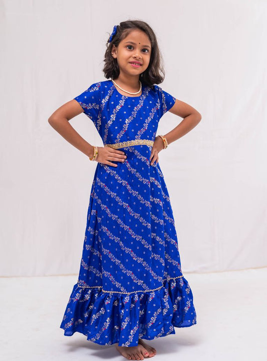 Ink blue banaras satin brocade silk gown with cap sleeves and ruffled flare for Girls.Let your princess be as comfortable as in her casuals with carefully designed & crafted Comfort Ethnic Wear by Soyara Ethnics.Keep her fashion quotient high with timeless patterns, vibrant combinations and royal textiles.
