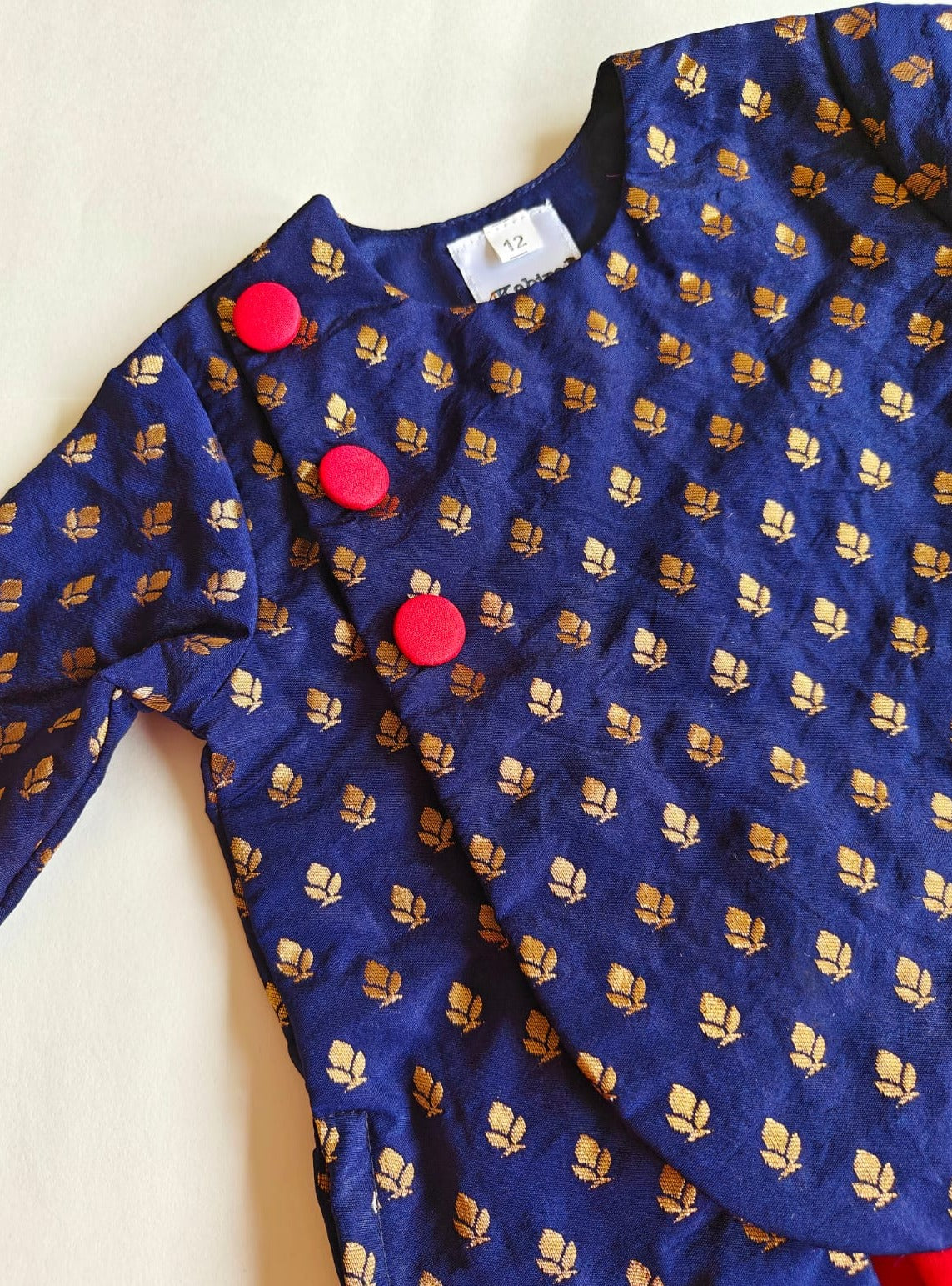 Navy blue brocade silk kurta with red fabric buttons teamed with red Italian crape silk dhoti for Baby Boy.It's the perfect outfit for your baby's naming ceremony,naamkaran,annaprashan ceremony.Traditional dress for Noolukettu Ceremony,Pachavi Puja,cradle ceremony,Rice Ceremony,Chatti Puja etc. Apt gifting idea