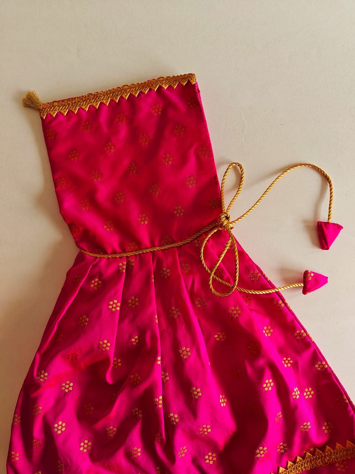 Dark Pink brocade silk kunchi with beautiful golden lace. Traditional design with a twist of small details like golden tassel and cute latkans. A must have for a naming ceremony of newborn baby.  Size - Suitable for 0-6 months