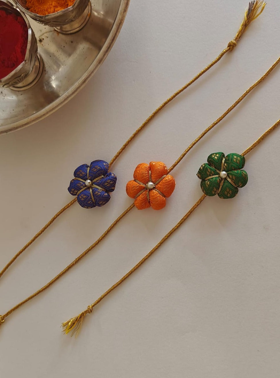 Fabric flower rakhi with golden cord Suitable for all ages.