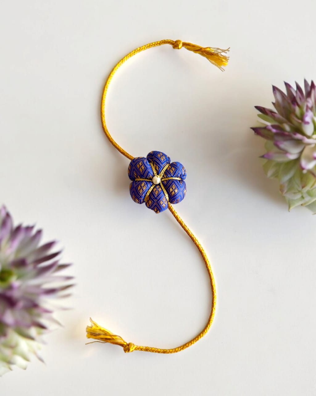 Fabric flower rakhi with golden cord