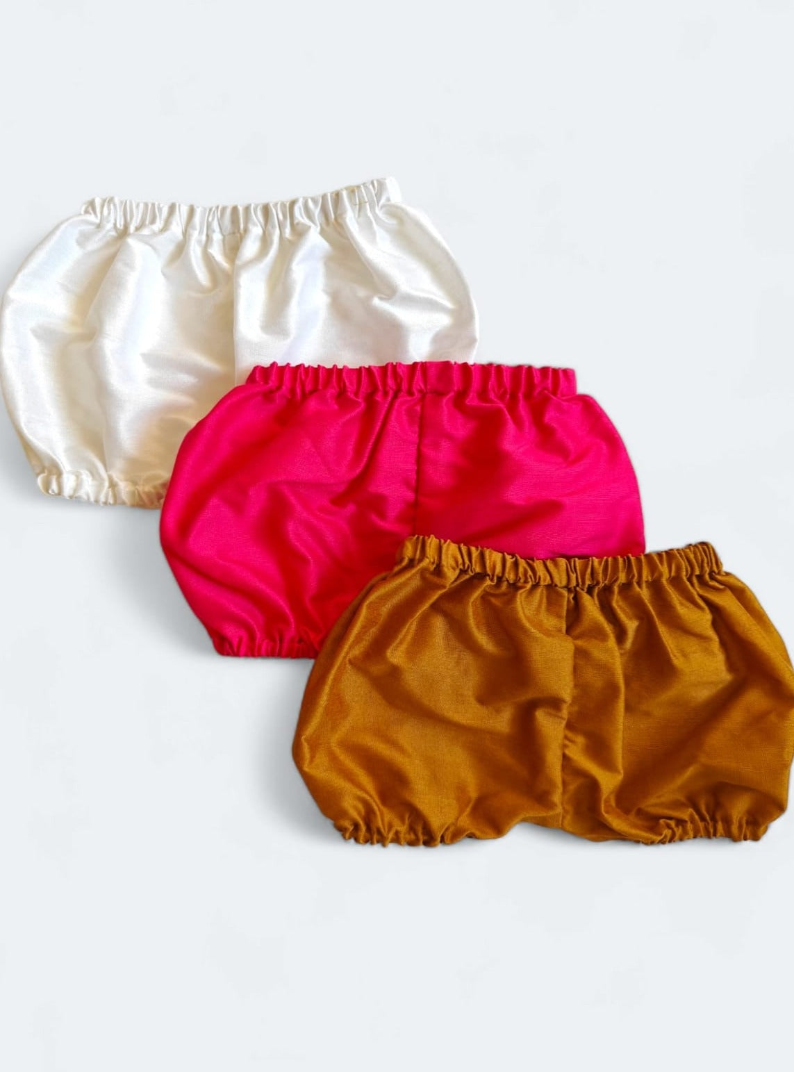 Set of 3 common coloured Baby Bloomers to use over a diaper for Newborn.Golden brocade bonnet,paithani booties,fabric headbands all these Handcrafted accessories for Newborn are perfect add ons to any traditional attire of the baby. Designer baby mats, set of generic bloomers are the other naming ceremony essentials.