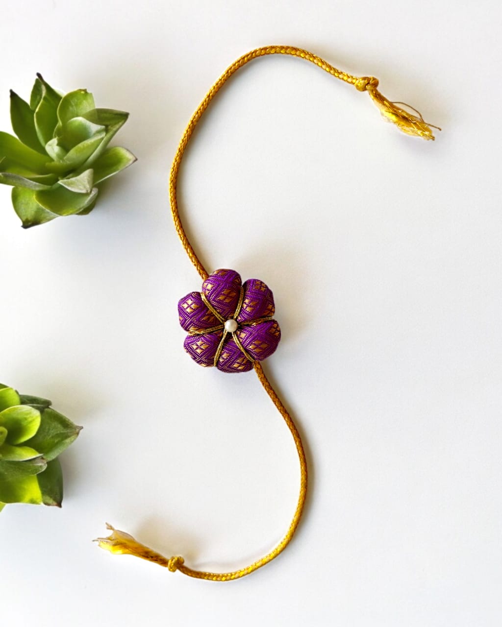 Fabric flower rakhi with golden cord