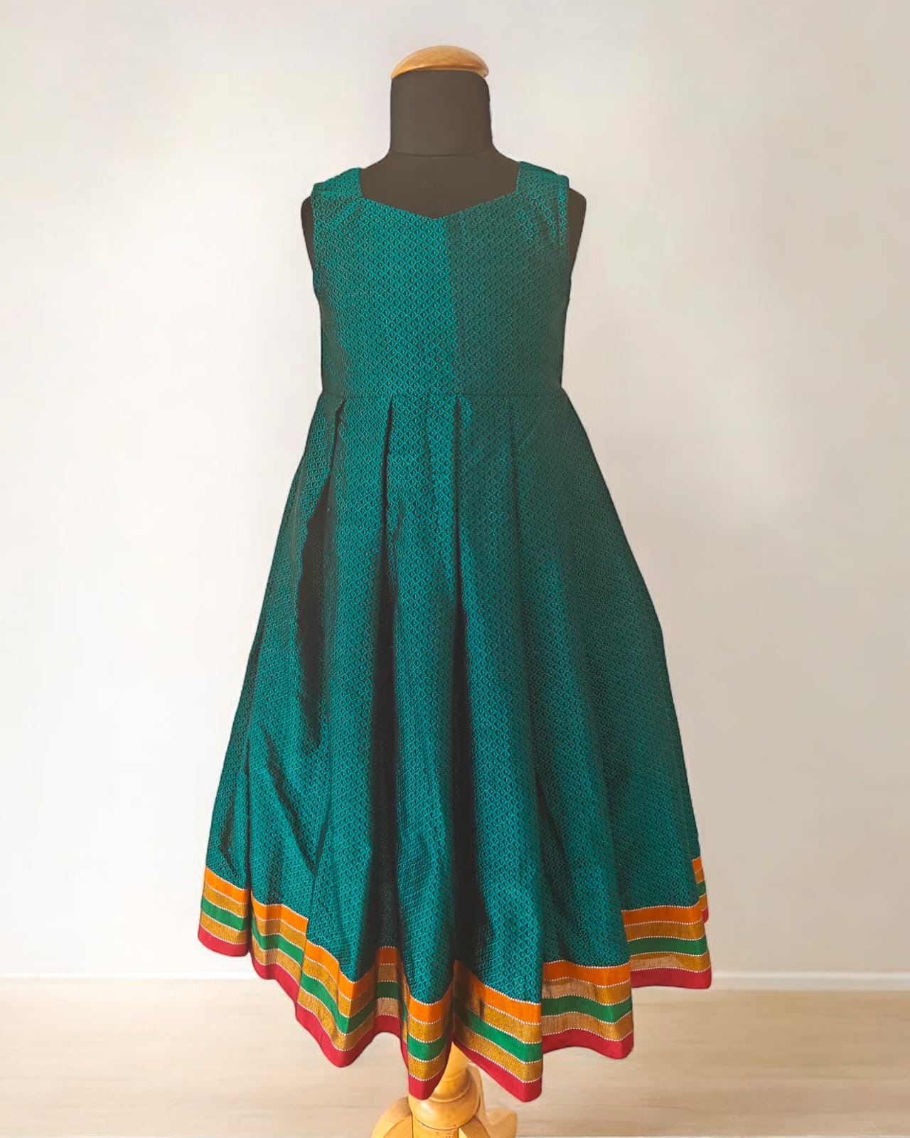 Peacock Green Khunn Dress with Contrast Turmeric Yellow hand embroidered blouse with cute puff sleeves. Apple cut blouse has cute flower latkans on both sides that dangle while walking. Also Unique Patti border of khunn is something not to miss for Khunn lovers