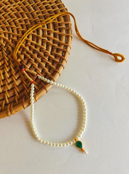 This necklace features semi-cultured pearls and a Karwari Drop shaped Green Stone Pendant, perfect for girls. The length is 13 inches with an adjustable drawstring for added convenience.
