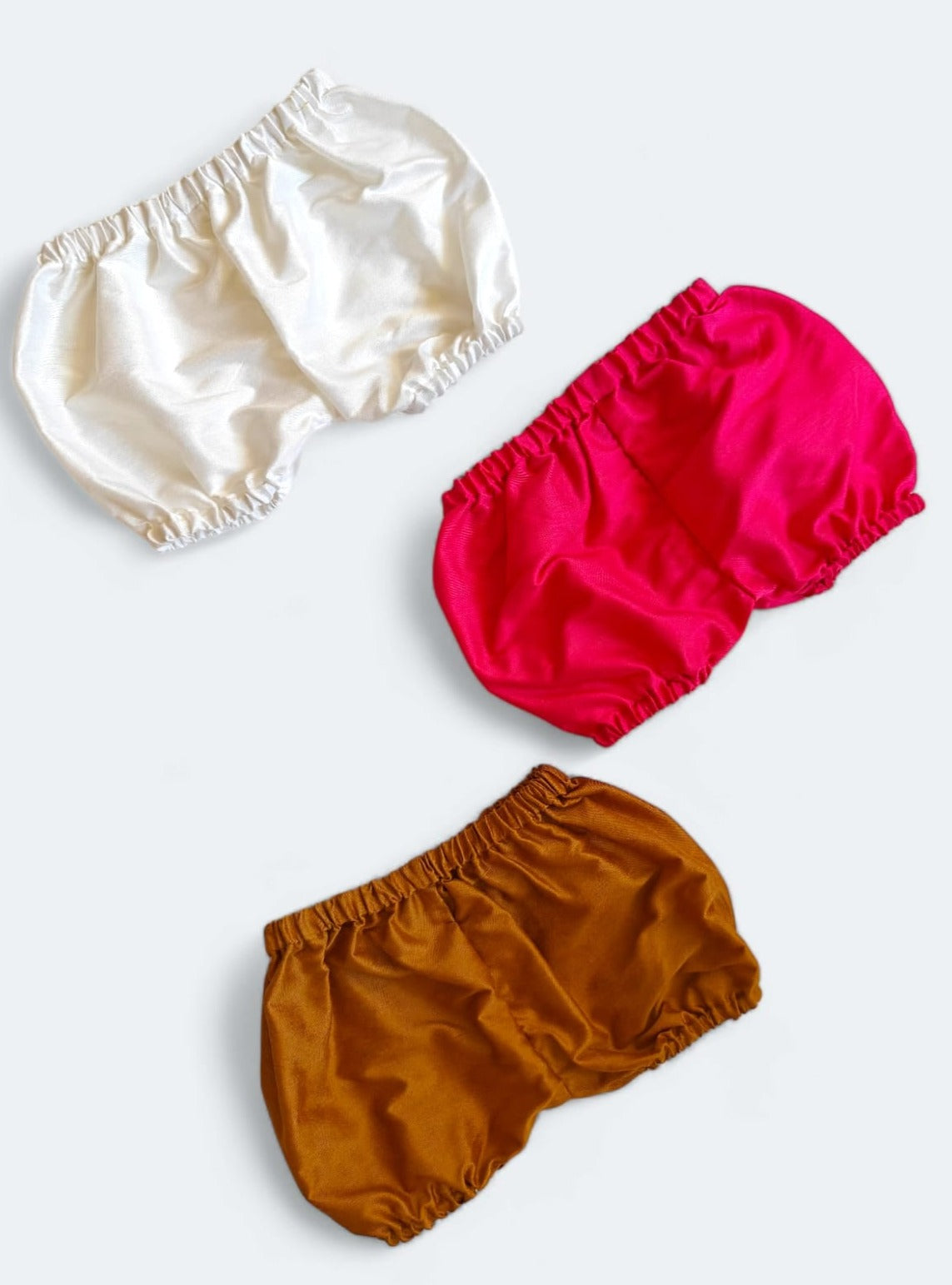 Set of 3 common coloured Baby Bloomers to use over a diaper for Newborn.Golden brocade bonnet,paithani booties,fabric headbands all these Handcrafted accessories for Newborn are perfect add ons to any traditional attire of the baby. Designer baby mats, set of generic bloomers are the other naming ceremony essentials.