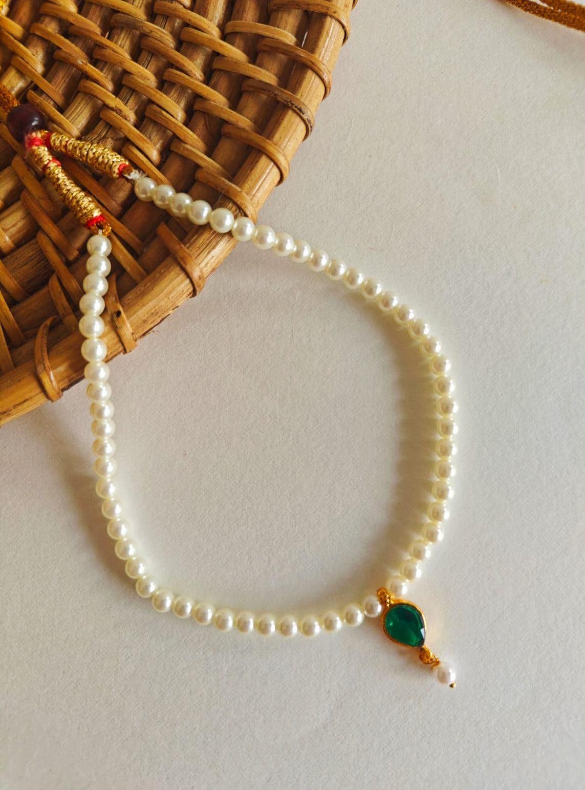 This necklace features semi-cultured pearls and a Karwari Drop shaped Green Stone Pendant, perfect for girls. The length is 13 inches with an adjustable drawstring for added convenience.