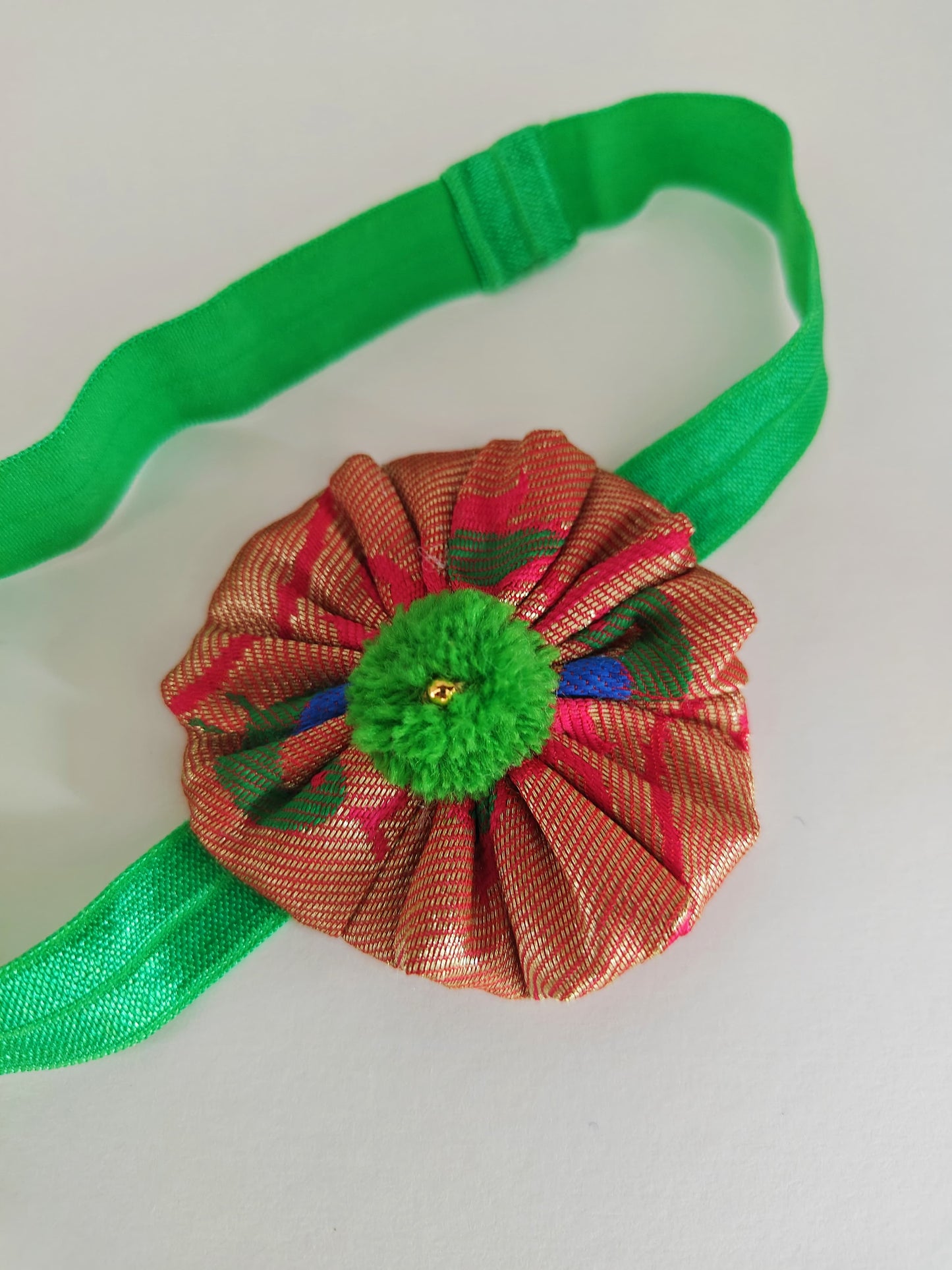 Green paithani fabric flower elasticated headband for baby girl.