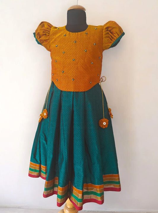 Peacock Green Khunn Dress with Contrast Turmeric Yellow hand embroidered blouse with cute puff sleeves. Apple cut blouse has cute flower latkans on both sides that dangle while walking. Also Unique Patti border of khunn is something not to miss for Khunn lovers