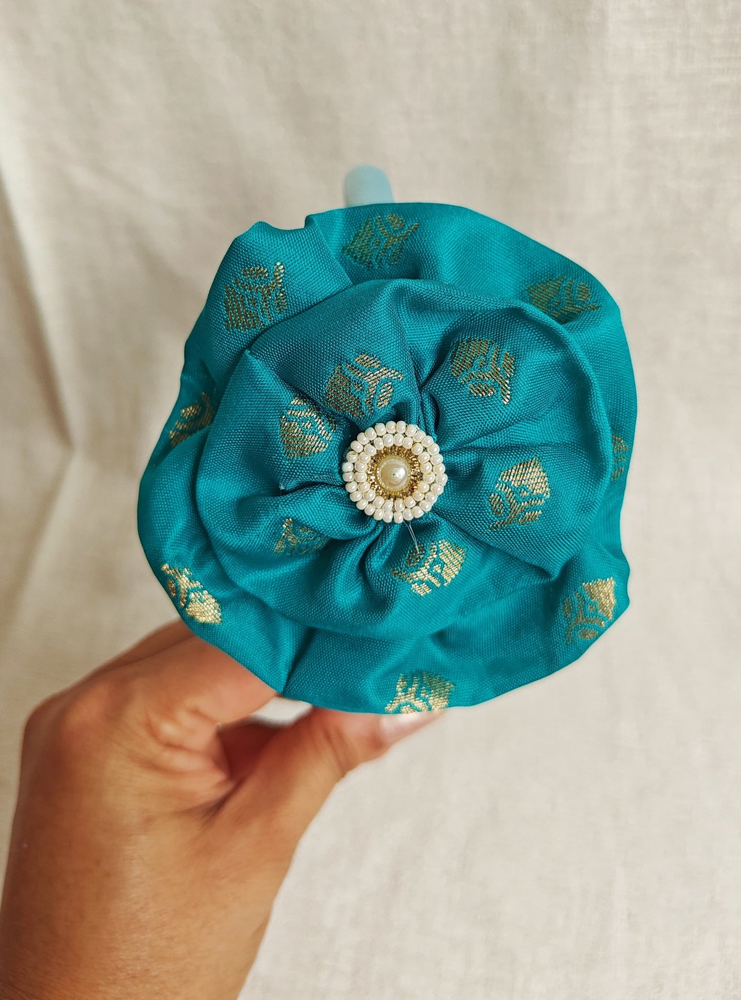 This Aqua Green Big Handcrafted fabric flower headband with pearls embellishment for Girls is expertly crafted with immense love and suitable for girls above the age of 2 years. The intricate handwork and delicate pearl detailing make it a standout accessory for any young girl.