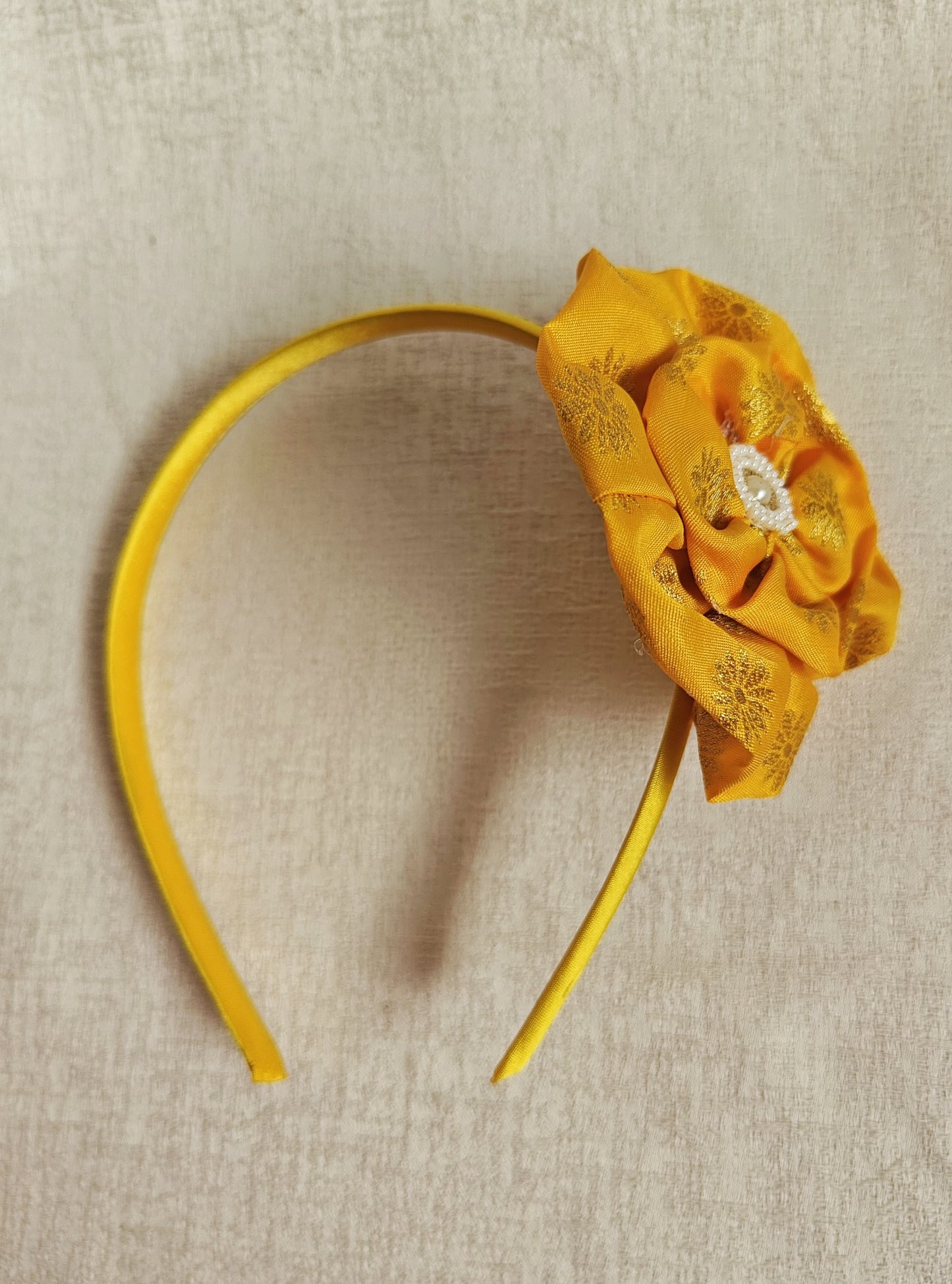 This Yellow Big Handcrafted fabric flower headband with pearls embellishment for Girls is expertly crafted with immense love and suitable for girls above the age of 2 years. The intricate handwork and delicate pearl detailing make it a standout accessory for any young girl.