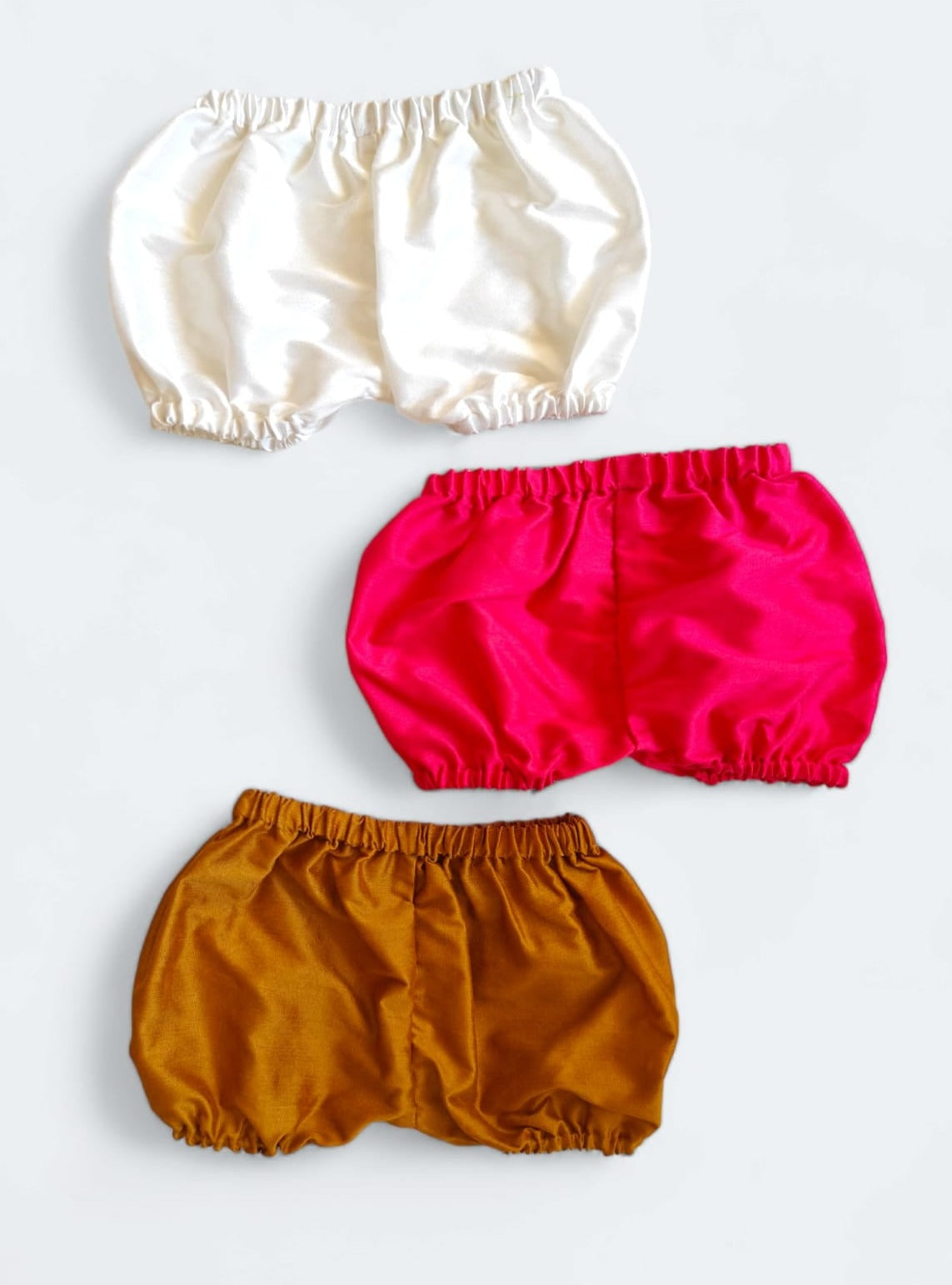 Set of 3 common coloured Baby Bloomers to use over a diaper for Newborn.Golden brocade bonnet,paithani booties,fabric headbands all these Handcrafted accessories for Newborn are perfect add ons to any traditional attire of the baby. Designer baby mats, set of generic bloomers are the other naming ceremony essentials.