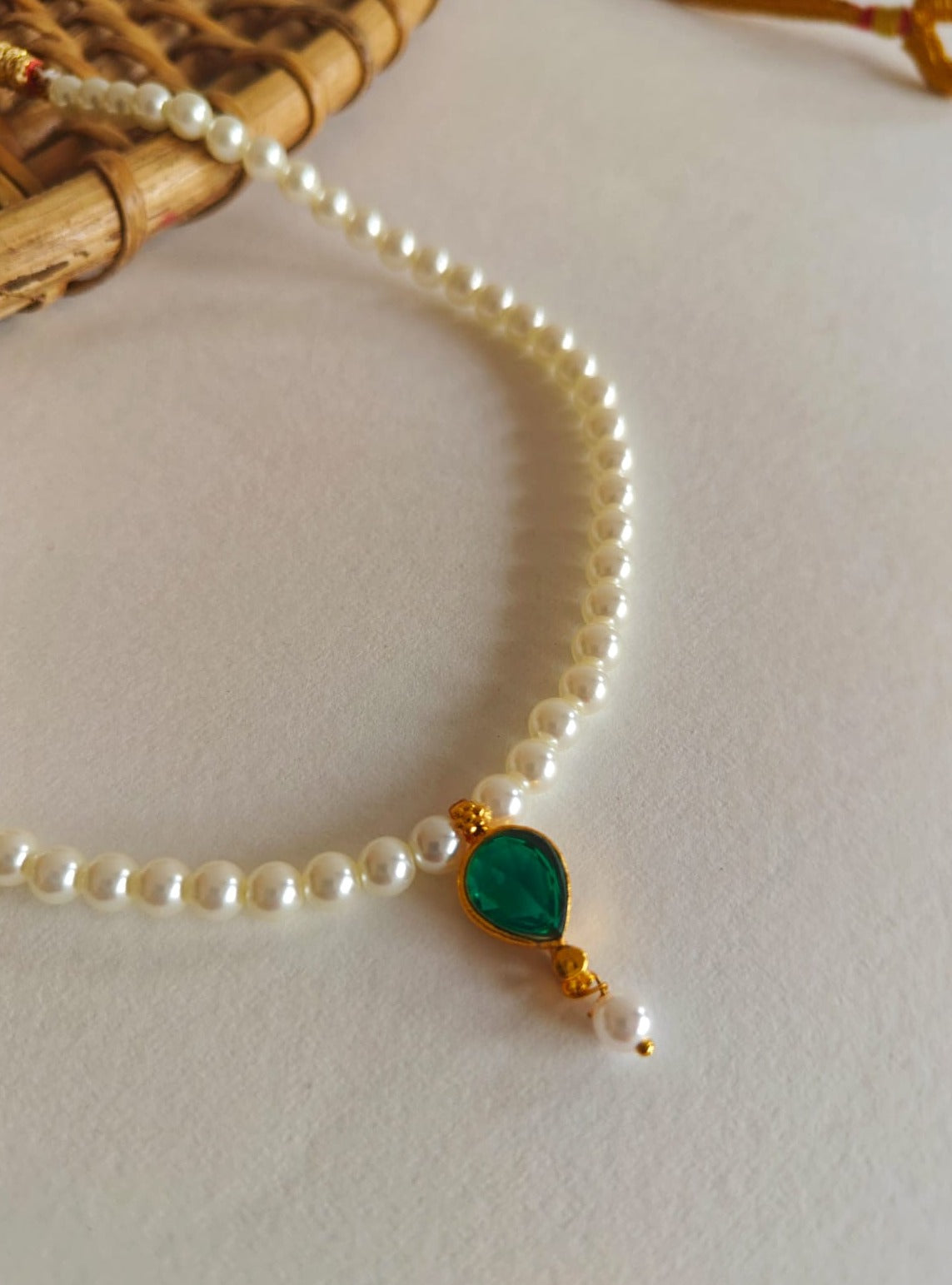 This necklace features semi-cultured pearls and a Karwari Drop shaped Green Stone Pendant, perfect for girls. The length is 13 inches with an adjustable drawstring for added convenience.