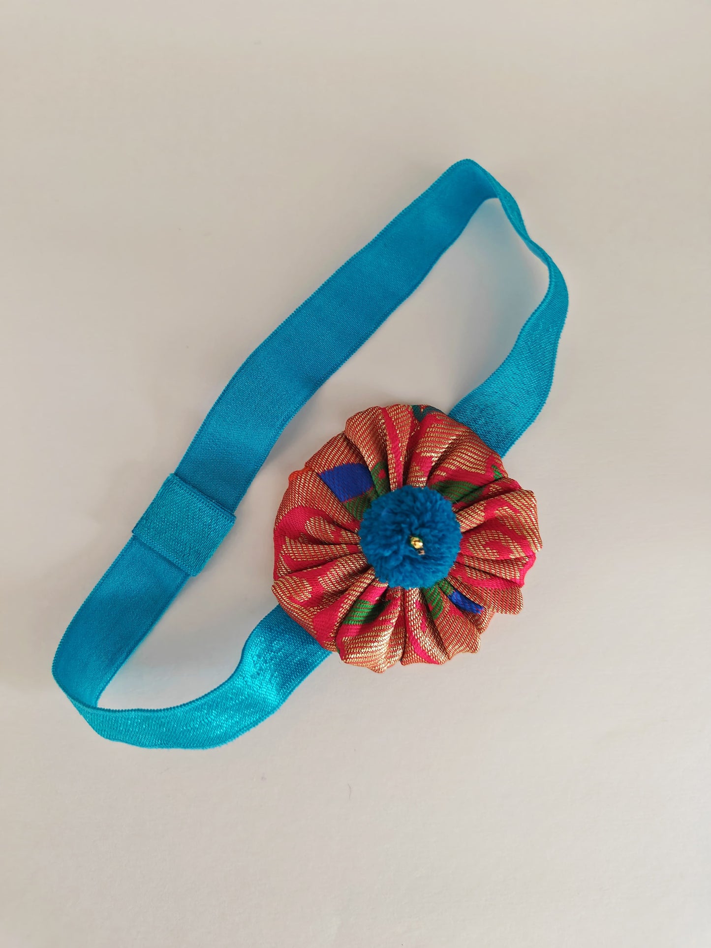 Teal blue paithani fabric flower elasticated headband for baby girl.