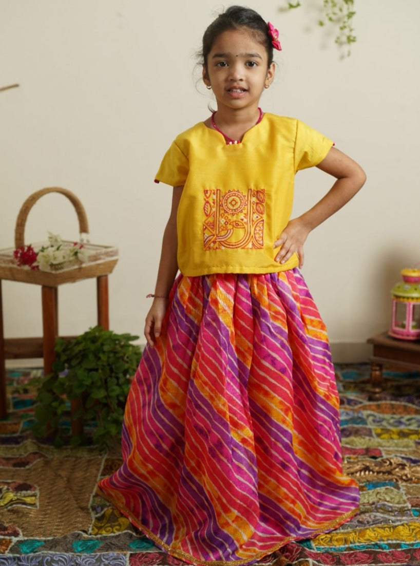 Purple pink yellow leheriya kotta elasticated long skirt with sunshine yellow cotton silk crop top.Let your princess be as comfortable as in her casuals with carefully designed & crafted Comfort Ethnic Wear by Soyara Ethnics.Keep her fashion quotient high with timeless patterns, vibrant combinations and royal textiles.