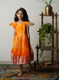 Orange organza dress with subtle shibori print and woven silver jari border for Girls.Let your princess be as comfortable as in her casuals with carefully designed & crafted Comfort Ethnic Wear by Soyara Ethnics.Keep her fashion quotient high with timeless patterns, vibrant combinations and royal textiles.